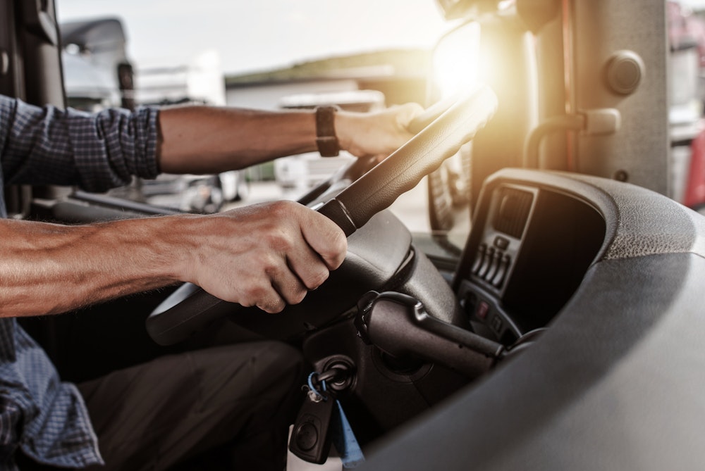Truck driver's hands on steering wheel