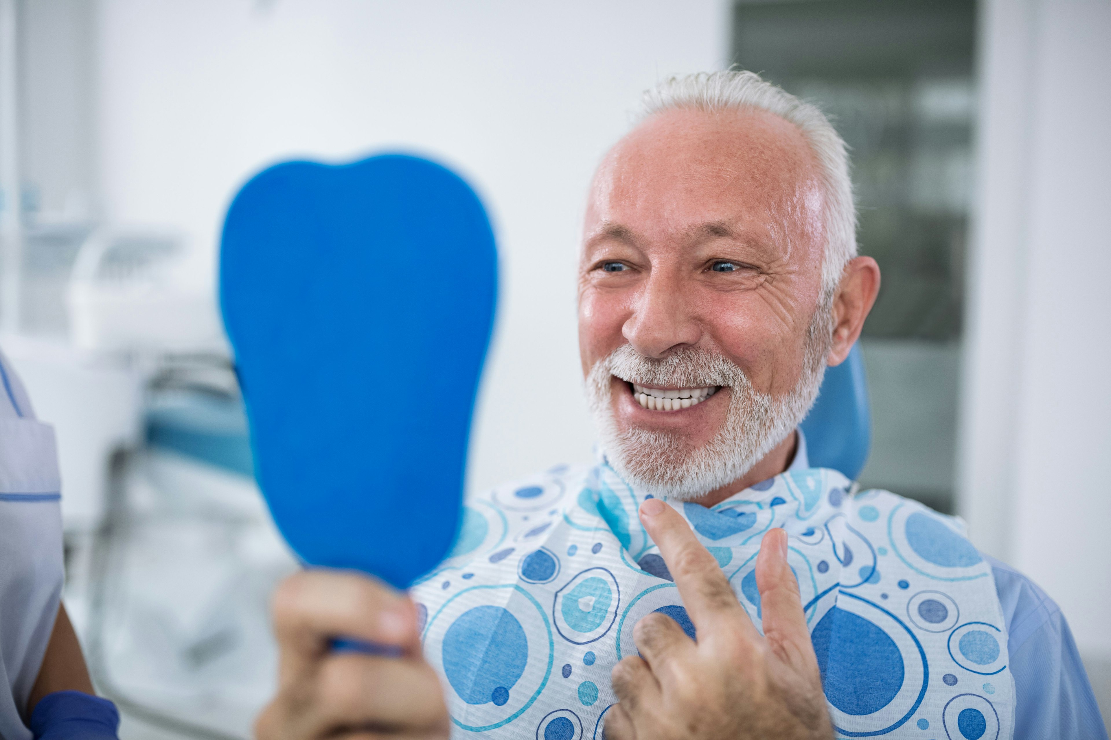 A man looking in the mirror at the dentist's office