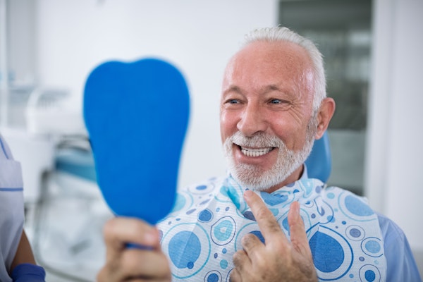Dental patient pointing at his smile