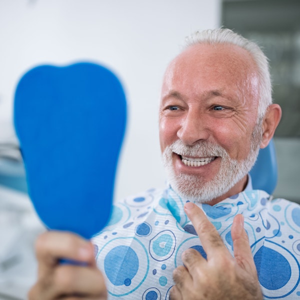 Dental patient pointing at his smile