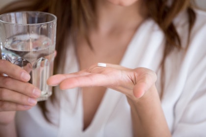 Woman taking medication after a breast lift