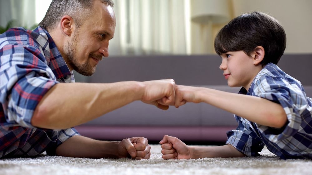 Father and son fist bump