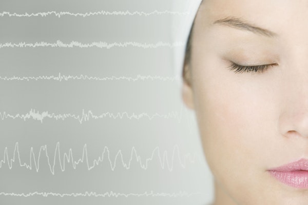 Brain wave lines running through head of woman with closed eyes