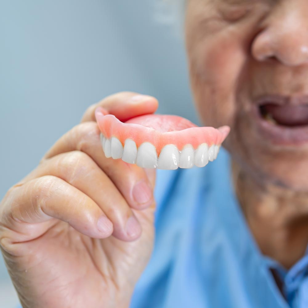 Elderly patient holding denture