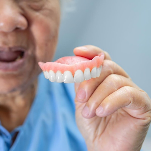 Elderly patient holding denture