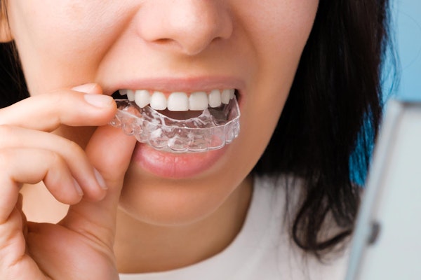 Woman taking off Invisalign