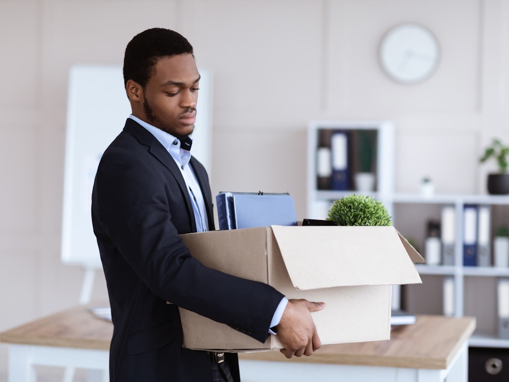 Fired worker carrying things in a cardboard box