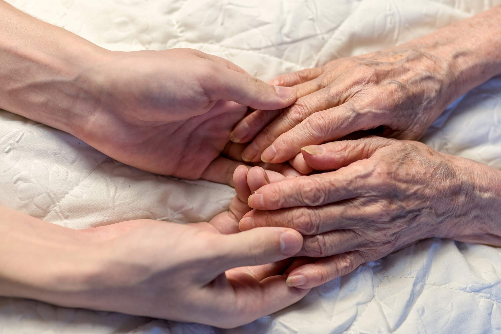 elderly hands being held