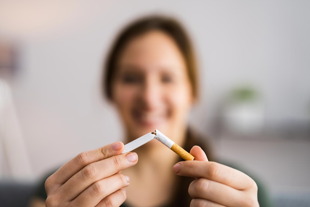 Woman breaking a cigarette in half