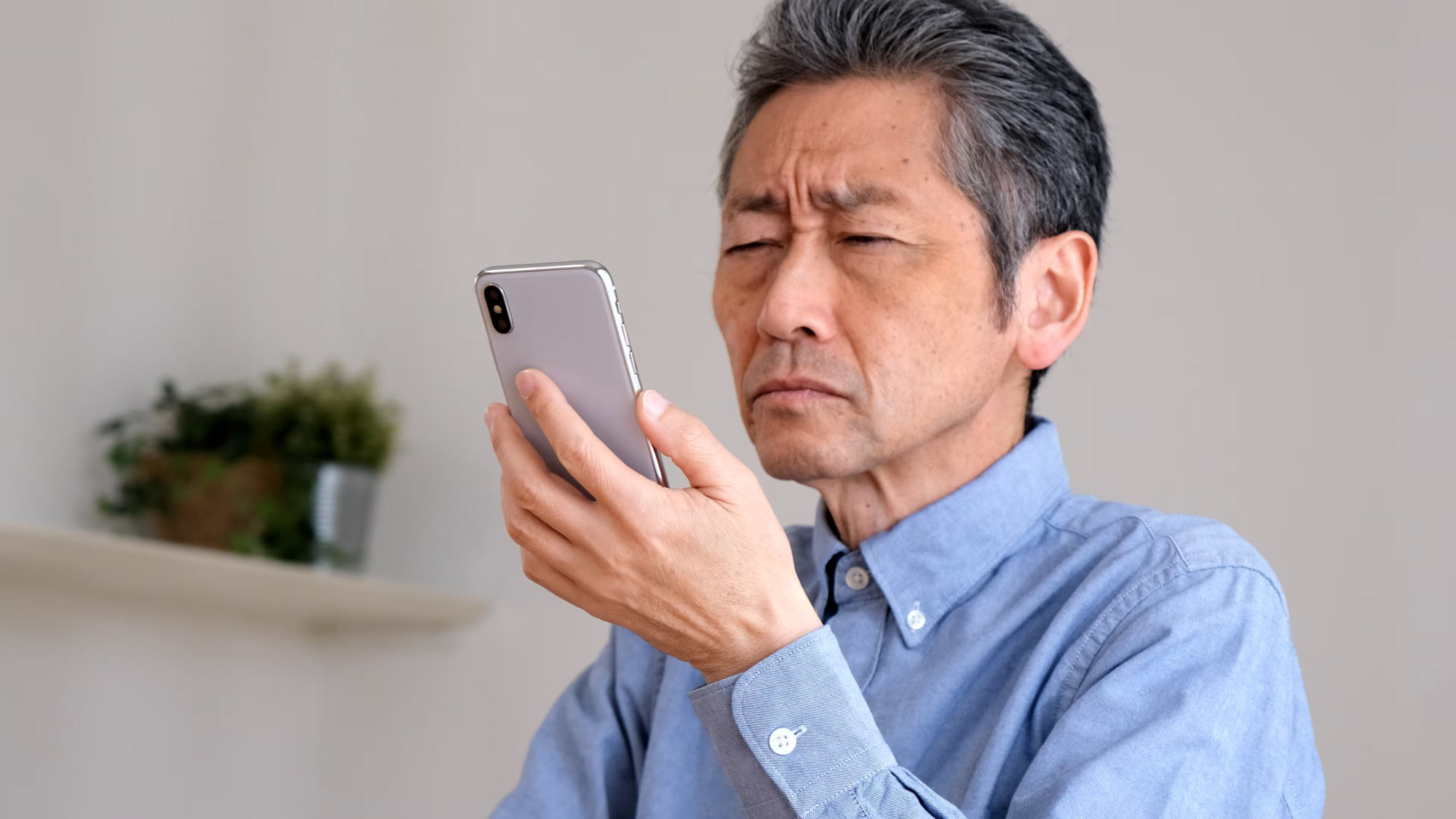 Mature man struggling to read on phone