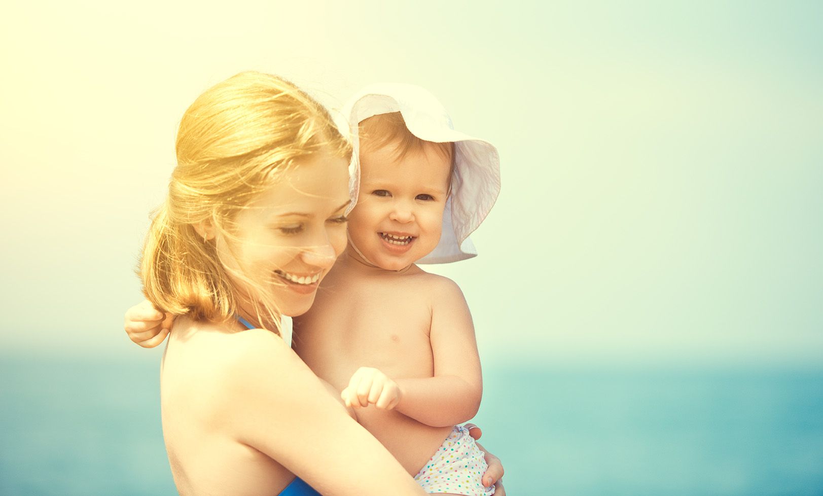 A mother holding her child at the beach