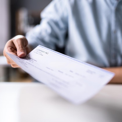 Person handing over compensation check