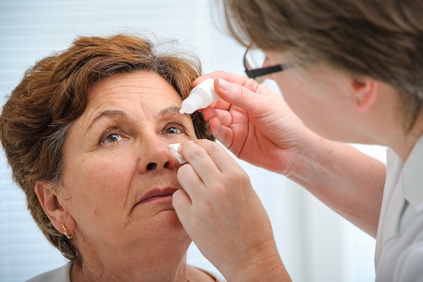 Doctor placing drops in woman's eye
