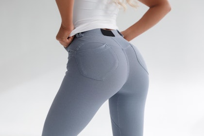 Woman's butt in grey jeans and white t-shirt