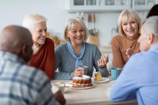 group of mature adults sharing a cake