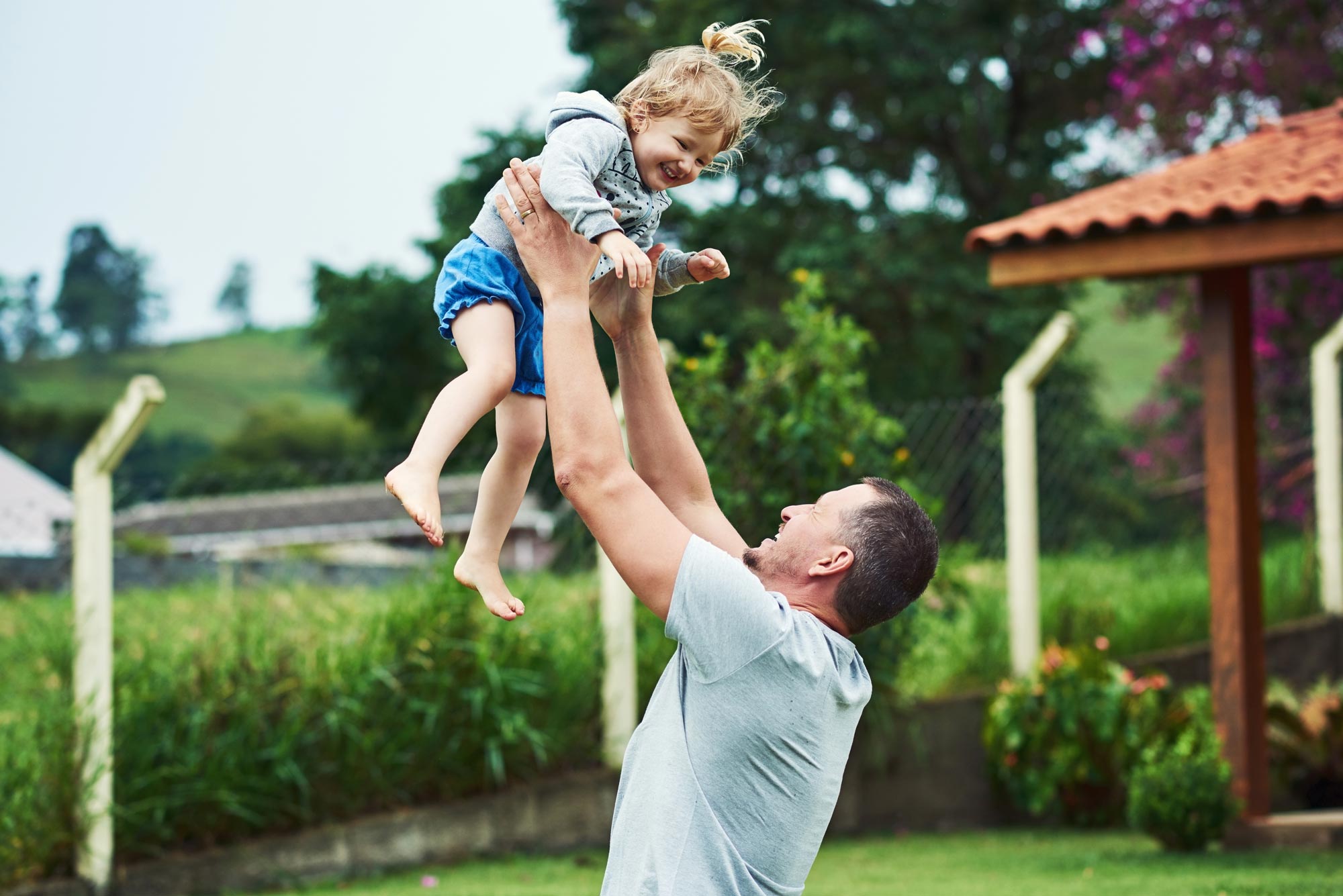 father lifting up daughter in arms
