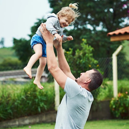 father lifting up daughter in arms