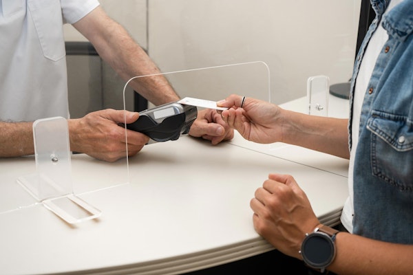 Dental patient handing over credit card to make payment