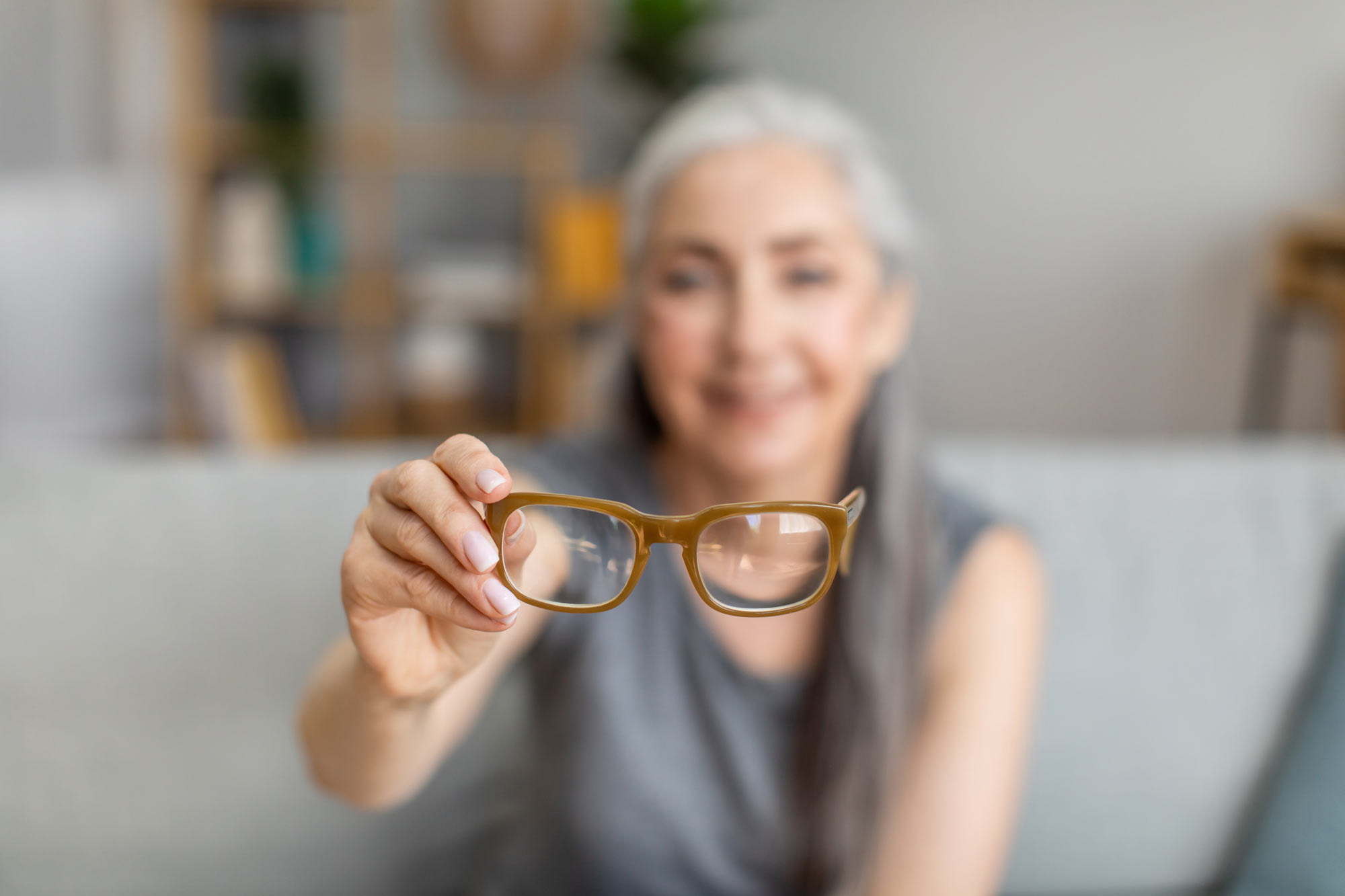 Mature woman holding glasses far away