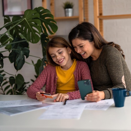 Laughing mother and young daughter at home