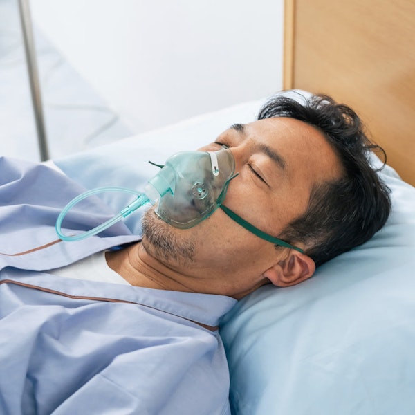Man in hospital bed on oxygen