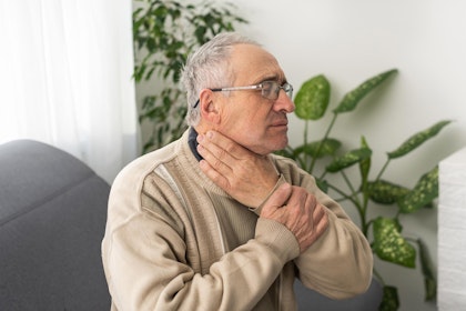 Older man touching face