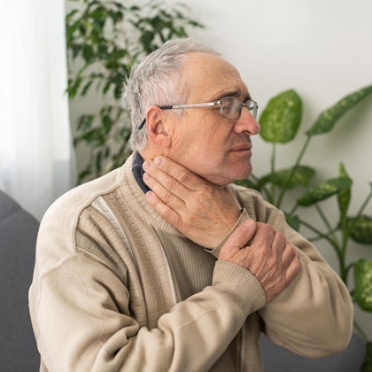Older man touching face