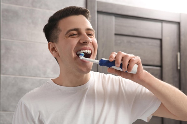 Man with veneers brushing his teeth