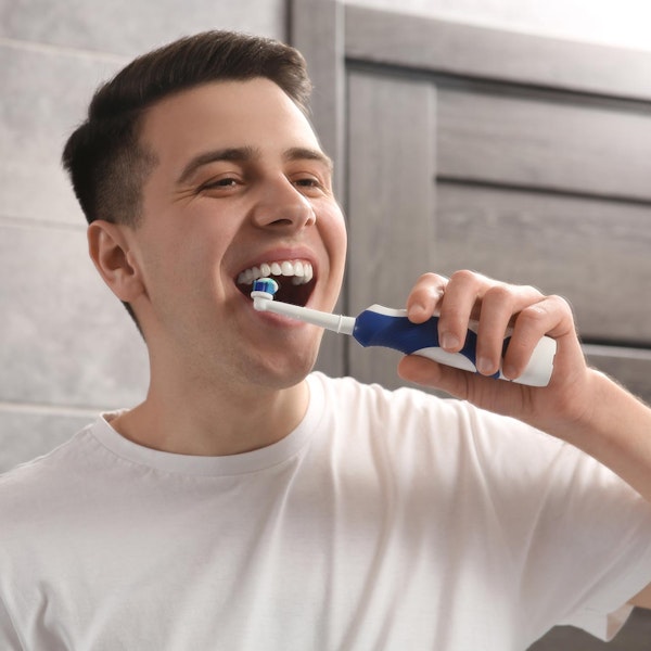 Man with veneers brushing his teeth