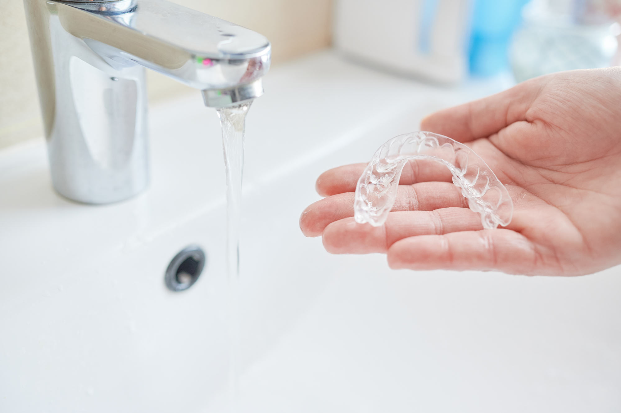 Running faucet and invisalign in hand