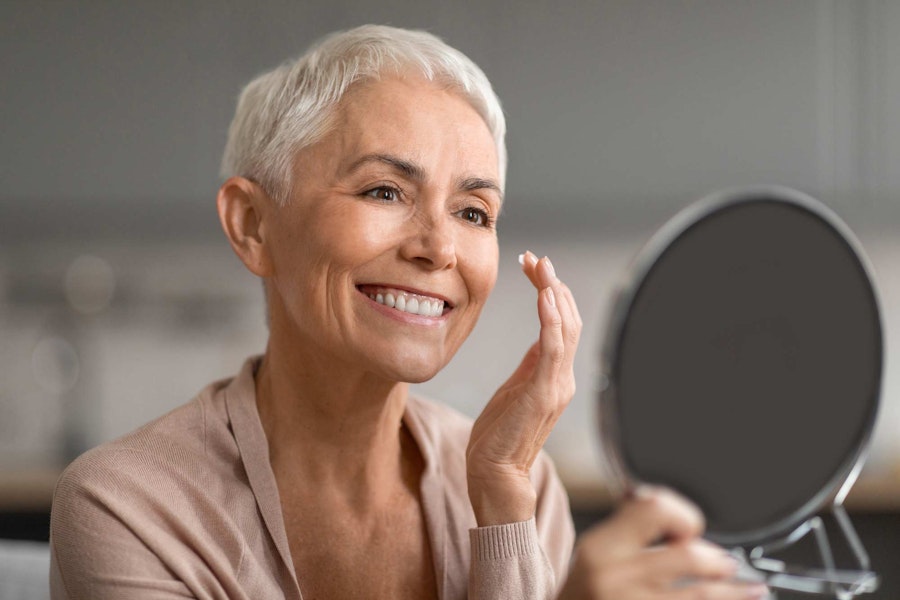Mature woman looking at face in the mirror