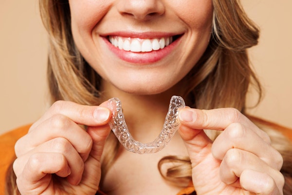 Woman holding Invisalign tray