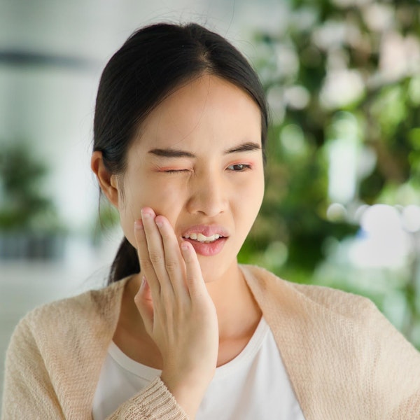Woman holding hand to jaw