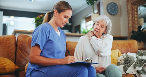 Nursing home resident going over paperwork with a caregiver