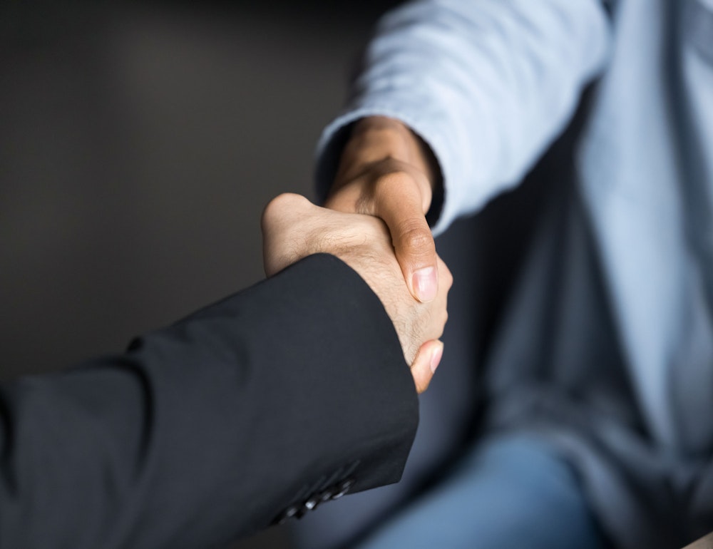 Two people shaking hands in a professional setting