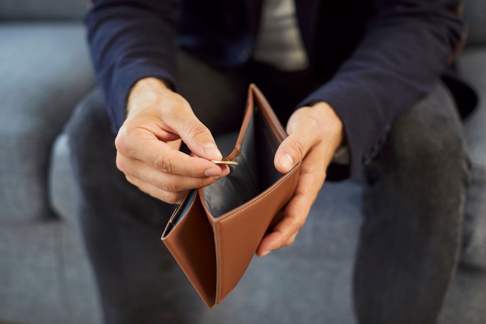 Man pulling single coin out of his wallet