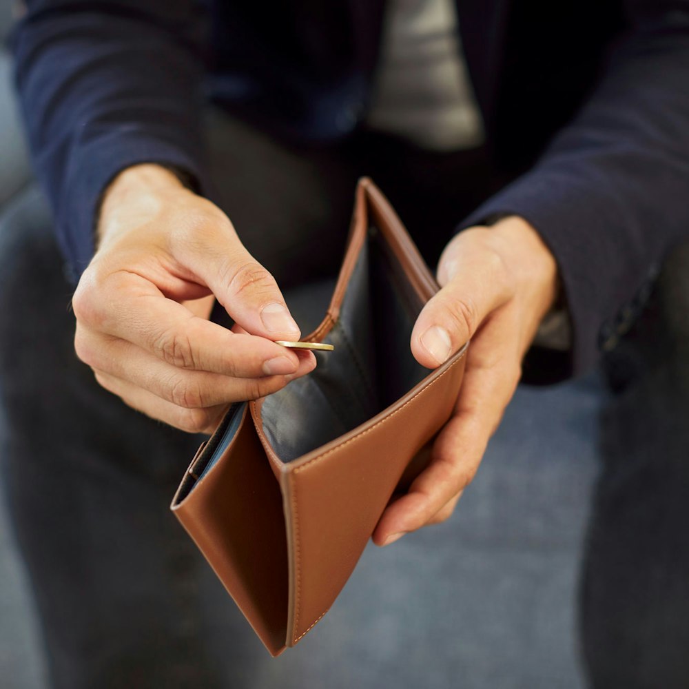 Man pulling single coin out of his wallet