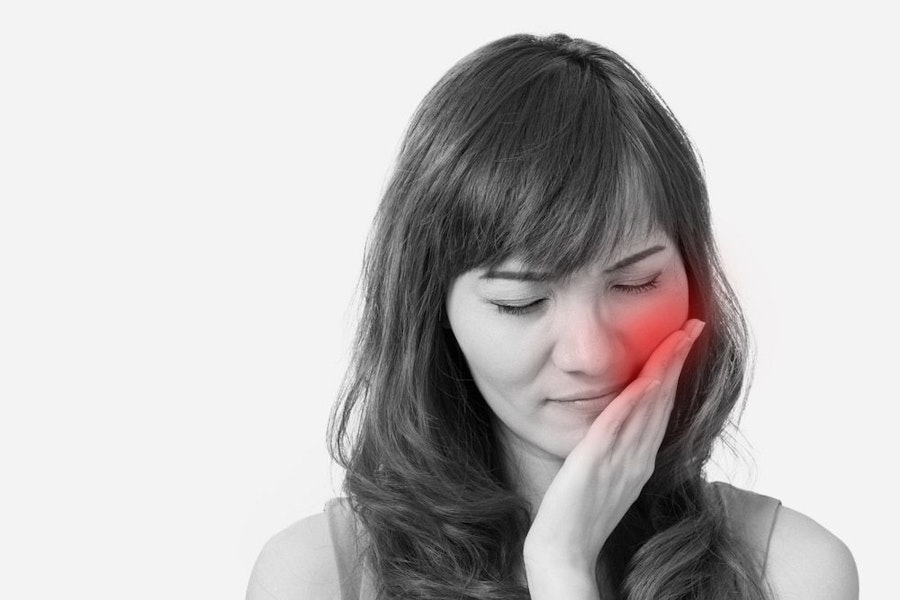 Woman holding jaw in pain