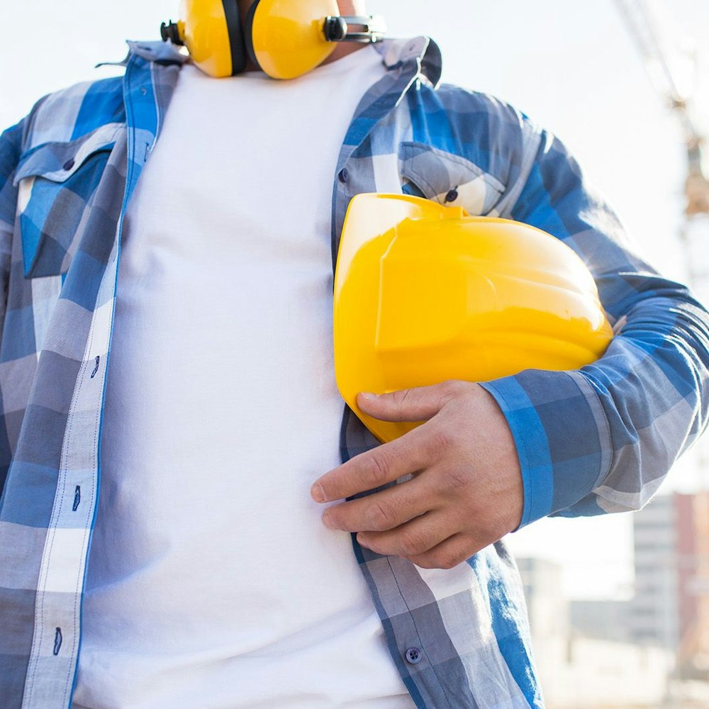 Man holding hard hat under arm