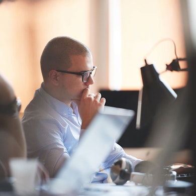 Man with hand to face looking at computer
