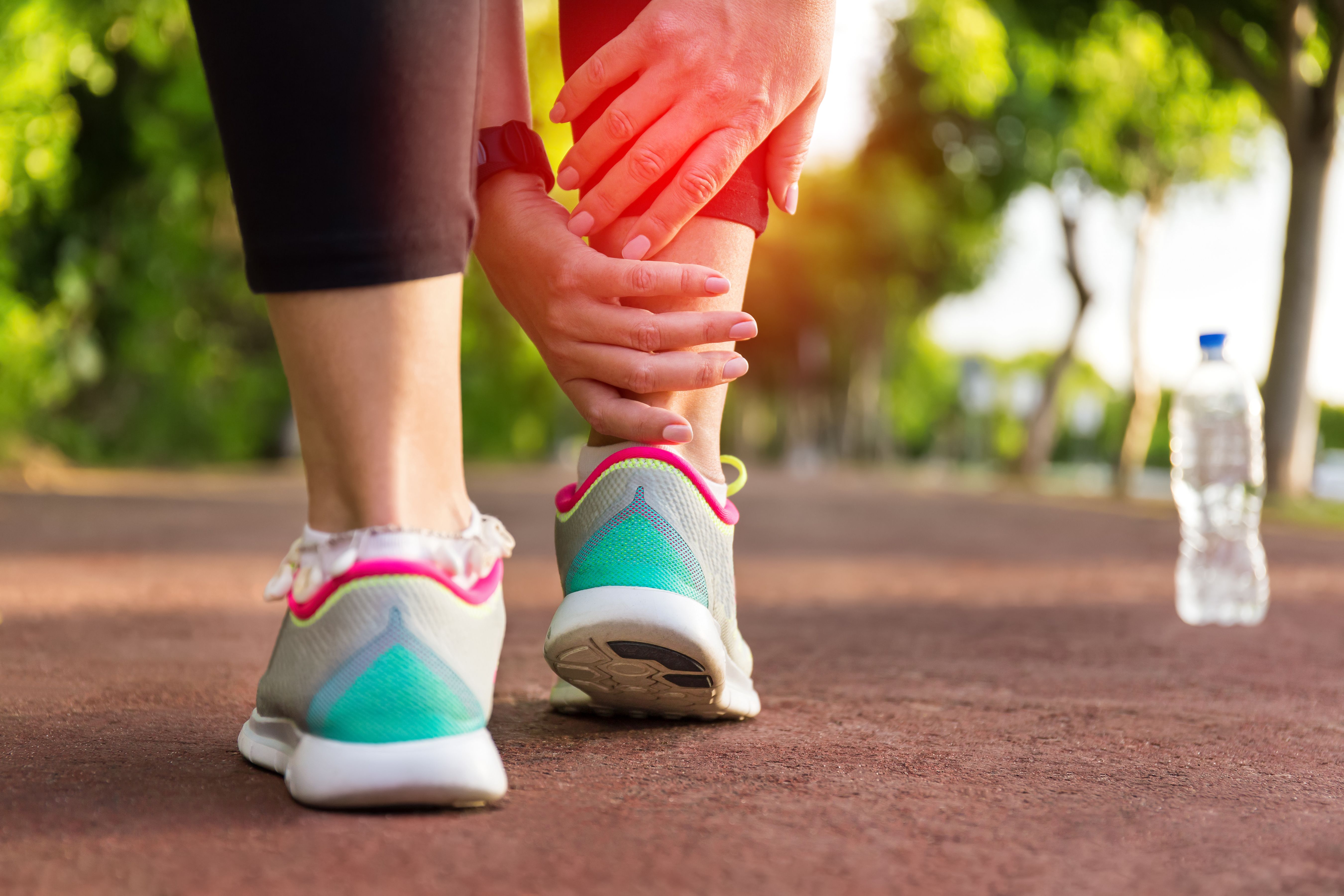 Person holding ankle in pain after running