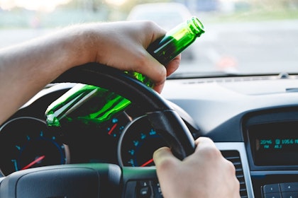 Driver holding alcohol bottle