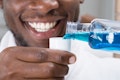 man smiling while pouring mouthwash