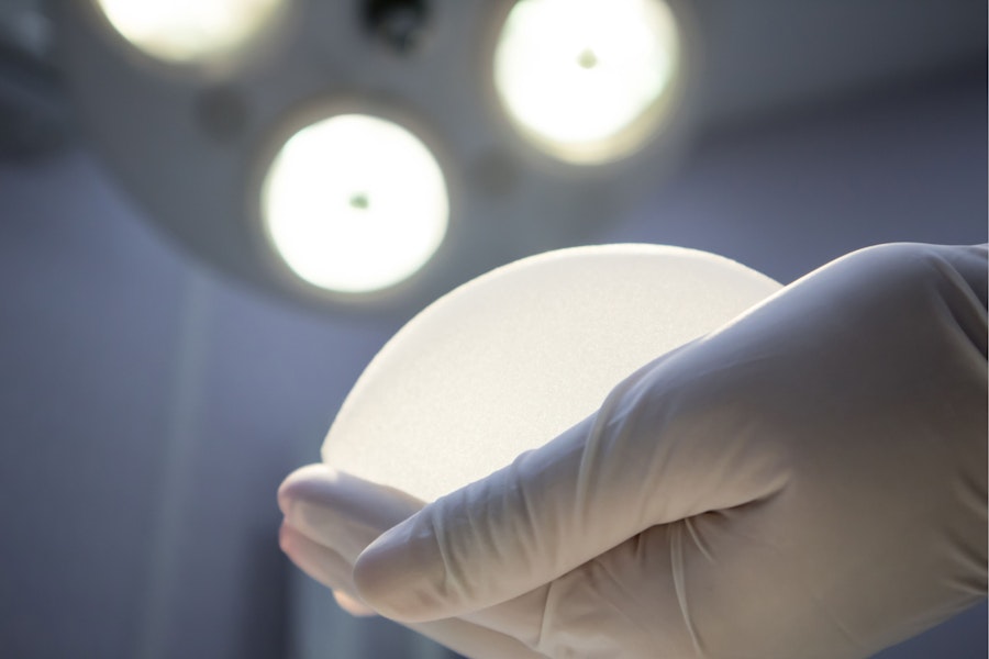 Breast implant in gloved hand