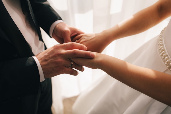 Couple in wedding attire holding hands
