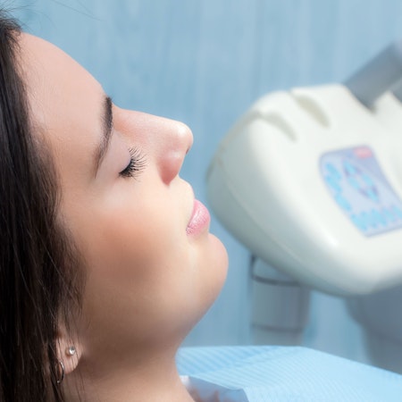 A woman with her eyes closed in a dental chair