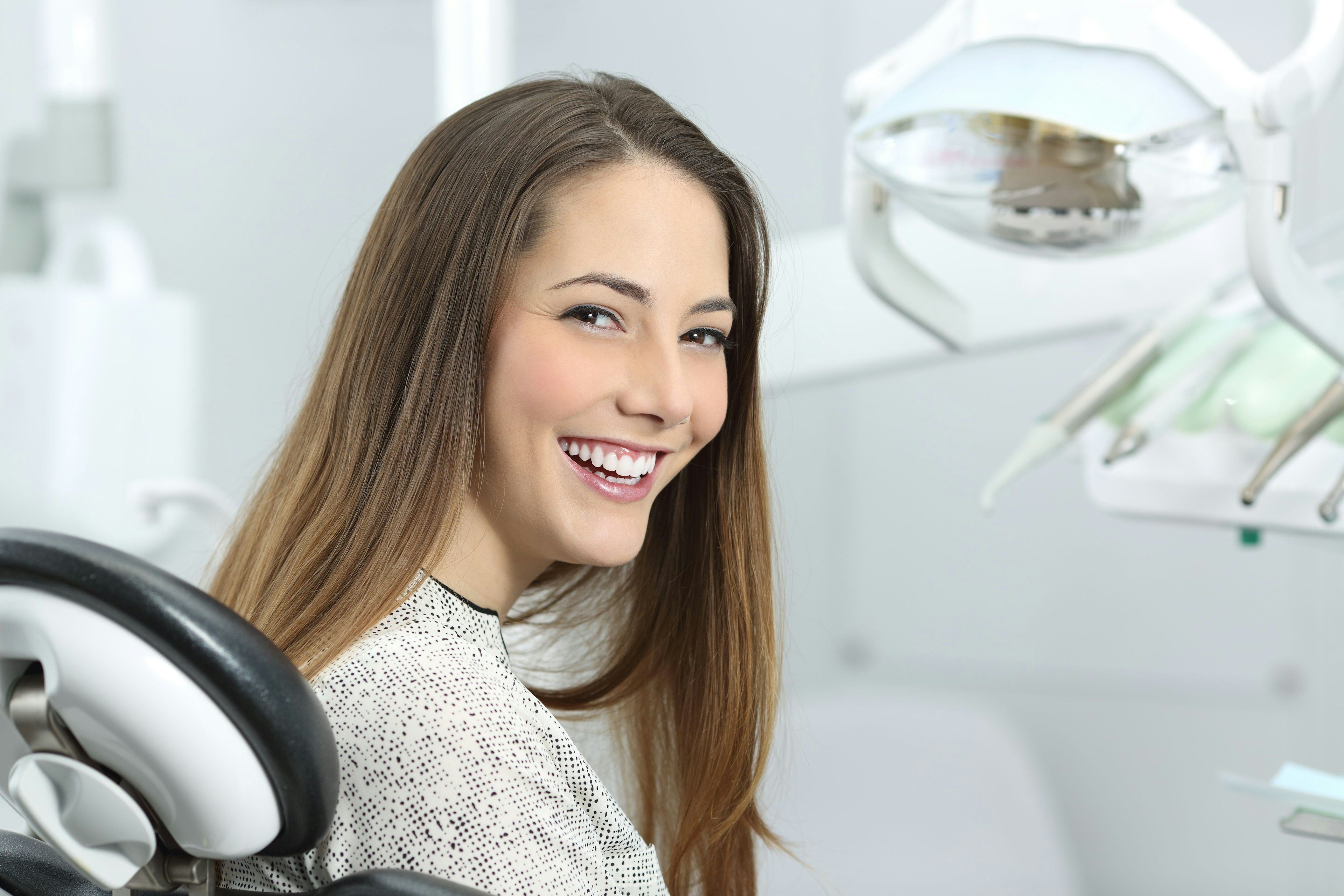 Woman sitting in a dental chair smiling