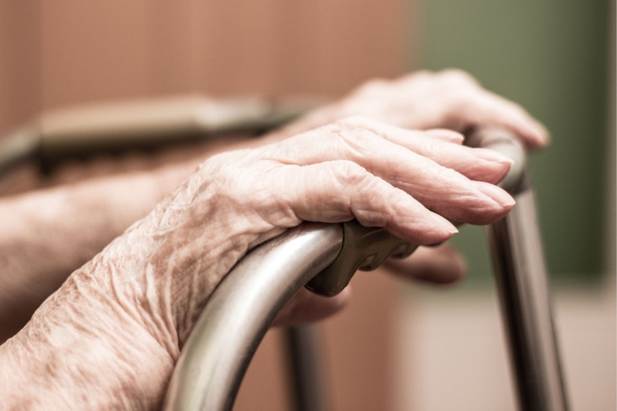 close up of an older person's hands on a walker