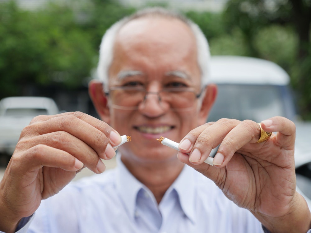 Man breaking cigarette in half