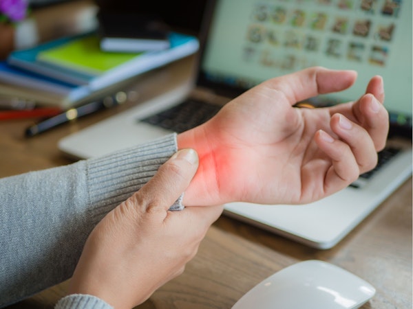 Woman holding wrist with red demonstrating pain